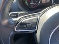 A close-up of the steering wheel controls of a 2016 Audi A3 featuring buttons for navigation and settings