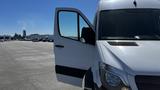 A white 2016 Mercedes-Benz Sprinter van with an open driver's side door showcasing the front view of the vehicle