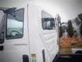 A white 2006 International 4300 truck with a cab and side view mirror visible in the foreground