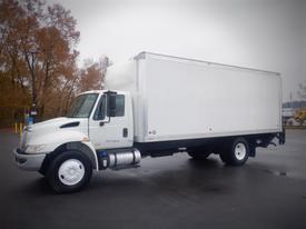 A white 2017 International 4300 box truck with a large cargo compartment and a silver grille is parked with its wheels visible and clean lines