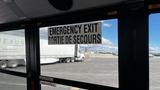 A 2014 Freightliner Thomas diesel bus interior showing an emergency exit sign in English and French