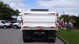 A 2014 International 7500 truck with a white rear dump bed facing forward