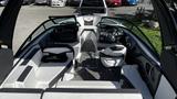 Interior view of a 2023 Mercury Monterey boat featuring plush seating and a modern dashboard with steering wheel and display screens