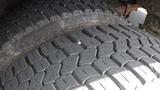 Close-up view of the tread on a 2011 Ford Econoline tire showing detailed patterns and a small object embedded in the rubber surface