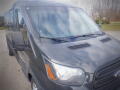 A black 2015 Ford Transit van showcasing its front view with visible headlights grille and side mirrors