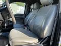 A 2017 Ford F-150 interior featuring two front seats with light gray leather upholstery and seatbelts visible