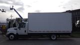 A white 2012 International TerraStar truck with a closed cargo box sits parked with its side facing the viewer