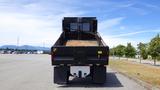 A 2012 International DuraStar 4300 dump truck with its bed raised, showcasing the interior load area and a grille at the back