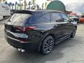 A black 2023 Acura MDX with sleek lines and sporty design featuring dark rims and dual exhaust outlets