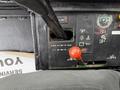 Control panel of a 1994 John Deere F1145 featuring various dials switches and a red gear lever