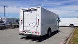 A white 2011 Ford Econoline with a box-style cargo area and rear loading door parked in a lot