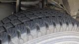 A close-up view of a worn tire from a 2011 Ford Econoline showcasing its tread pattern and surface details