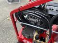 A red 2024 Magnum 4000 Hot Water Pressure Washer featuring high-pressure hoses and a compact design