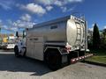 A silver 2013 Kenworth T370 fuel truck with a cylindrical tank labeled DIESEL and a side panel marked FUEL TRUCK. The vehicle features multiple wheels and a ladder on the rear