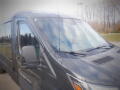 A 2015 Ford Transit van with a dark exterior and visible antenna on the roof