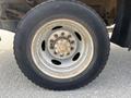 Close-up of a worn wheel on a 2010 Ford F-550 showing rust and dirt on the rim and tire