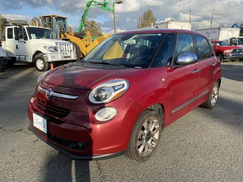 A red 2015 Fiat 500L parked with a compact design featuring rounded edges and large headlights designed for city driving and versatility