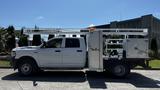 A white 2019 RAM 3500 with a flatbed and mounted equipment storage compartments