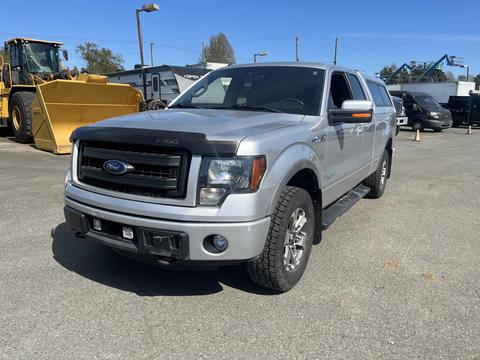 A silver 2014 Ford F-150 with a sleek design features a prominent front grille and large wheels