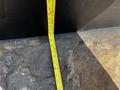 A yellow measuring tape laid flat on a rough surface with markings visible for measurements