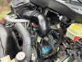 Engine compartment of a 2007 International 4200 with various hoses wires and a prominent black air intake pipe