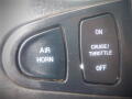 Close-up of a control panel with three buttons labeled Air Horn, On, and Cruise/Throttle with an Off position