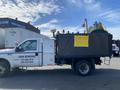 A 2003 Ford F-450 SD truck with a large black box on the back displaying a yellow sign that says "FOR SALE"