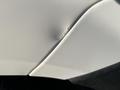 A close-up view of a dent on the white exterior panel of a 2013 Ford Expedition showing a crack in the paint and a bulging indentation