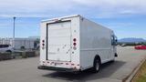 A white 2011 Ford Econoline cargo van with a large rear door and red tail lights parked in a lot