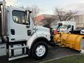 A 2006 Freightliner M2 106 truck with a yellow snow plow attached to the front