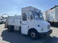 A white 2010 Freightliner MT45 garbage truck with a cab and side-loading compartment marked for a waste reduction program