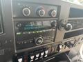 Dashboard controls of a 2018 Chevrolet Express showing radio display and various buttons for air conditioning and vehicle functions