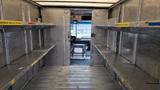 Interior of a 2006 Ford Econoline with metal shelves on either side leading to the front driver's seat area