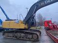 A 2014 John Deere 350G excavator with a yellow body and black arm on a construction site