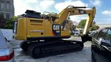 A yellow 2018 Cat 326F track excavator with a large bucket attachment parked between two vehicles