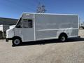 A white 2012 Ford Econoline delivery truck with a boxy shape and large cargo area visible from the side