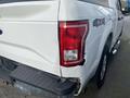 A white 2017 Ford F-150 with a damaged rear bumper and a red taillight