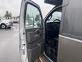 A 2017 Chevrolet Express van with an open driver's side door showing the interior and steering wheel