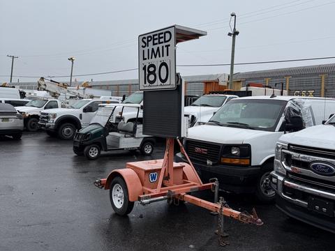 A 2011 Wanco Compact Radar-Speed Trailer with a sign displaying "SPEED LIMIT 180" on top and a digital screen for radar readings