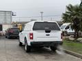 A white 2018 Ford F-150 truck with a canopy parked in a lot