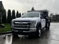 A 2021 Ford F-550 super duty truck with a flatbed in the foreground