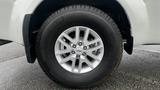 A close-up of the wheel of a 2016 Nissan Frontier showing a silver alloy rim and a black tire with tread patterns