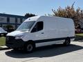 A 2022 Mercedes-Benz Sprinter van with a white exterior and black accent stripe parked on a paved area