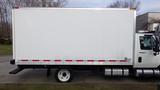 A white box truck with a flatbed and a silver side panel featuring red reflective strips