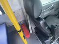 A black leather driver's seat inside a 2017 Chevrolet Express with a red toolbox positioned on the floor beside the seat