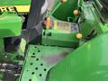 A 2003 John Deere 790 tractor featuring a green exterior with levers switches and pedals visible on the control panel