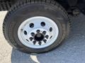 A close-up of a white wheel from a 2012 Ford Econoline showing six lug nuts and a Hankook Dynapro tire with visible tread