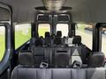 Interior view of a 2019 Mercedes-Benz Sprinter showing rows of black seats with seatbelts and overhead compartments