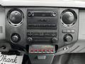 The interior dashboard of a 2011 Ford F-250 SD featuring a radio display center and various control knobs and buttons
