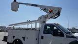 A white 2011 Ford F-450 Super Duty truck with a utility body and an elevated bucket lift attached on the passenger side